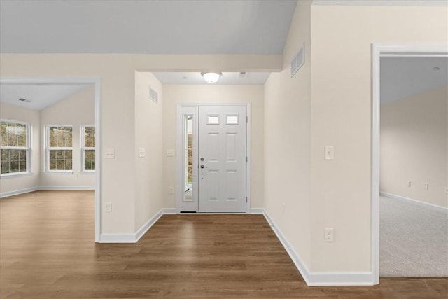 entrance foyer with wood-type flooring and vaulted ceiling