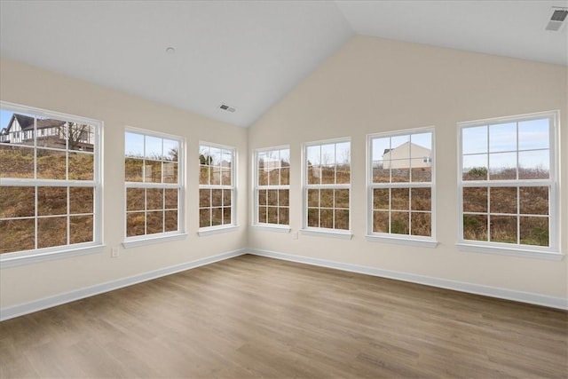 unfurnished sunroom featuring vaulted ceiling and a wealth of natural light