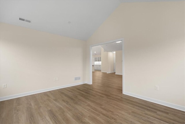 empty room featuring hardwood / wood-style floors and high vaulted ceiling