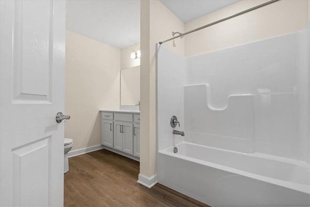 full bathroom featuring hardwood / wood-style floors, vanity, toilet, and  shower combination