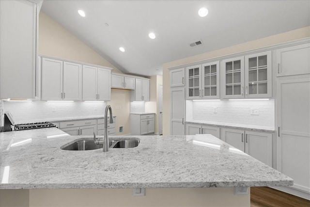 kitchen with backsplash, sink, white cabinets, and lofted ceiling