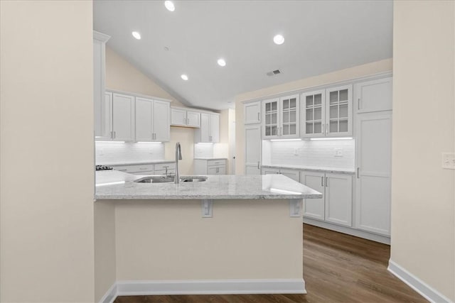 kitchen with sink, white cabinets, and vaulted ceiling