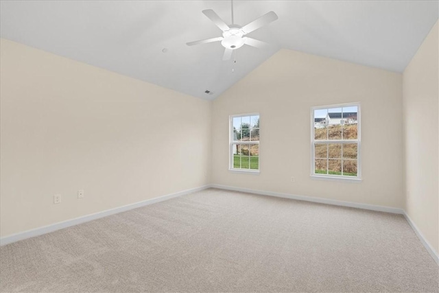 empty room with light colored carpet, vaulted ceiling, and ceiling fan