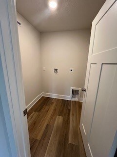 laundry room featuring hookup for an electric dryer, hookup for a washing machine, and dark hardwood / wood-style flooring