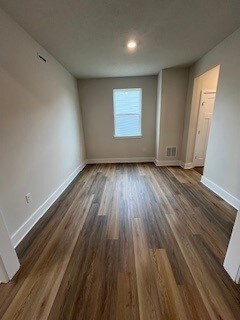 unfurnished room featuring dark hardwood / wood-style flooring