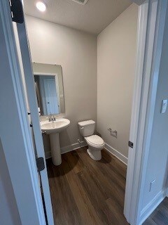 bathroom with hardwood / wood-style floors and toilet