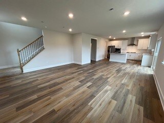 unfurnished living room with dark wood-type flooring