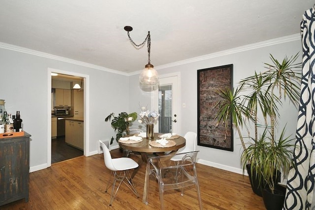 dining room with crown molding and dark hardwood / wood-style flooring