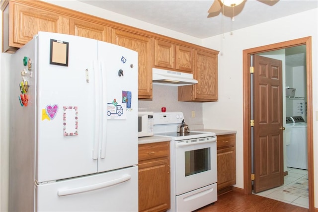 kitchen featuring white appliances, light hardwood / wood-style flooring, ceiling fan, and washing machine and dryer