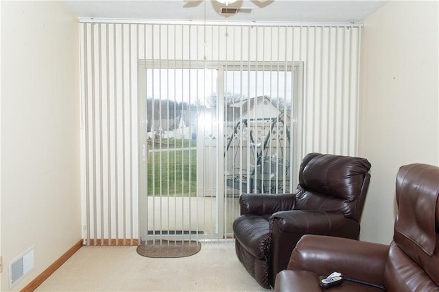 living area with carpet flooring, a wealth of natural light, and ceiling fan