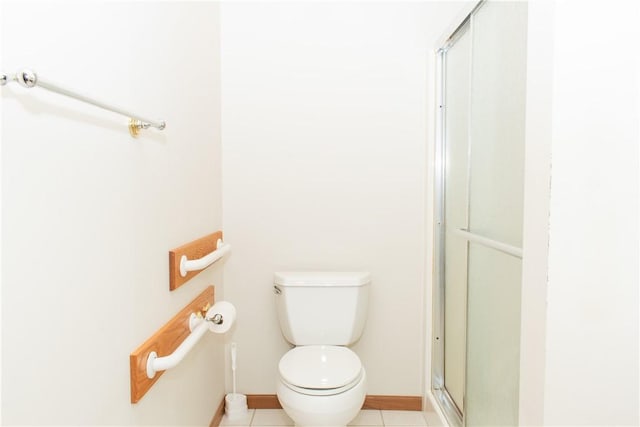 bathroom with tile patterned flooring, toilet, and an enclosed shower