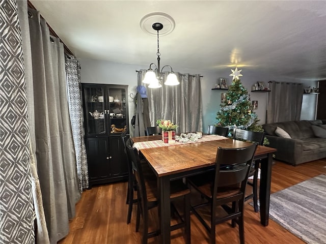 dining area with dark hardwood / wood-style flooring and a notable chandelier