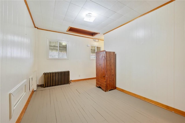 interior space with radiator heating unit, light hardwood / wood-style flooring, and crown molding