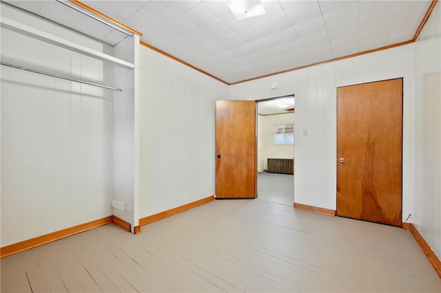 unfurnished bedroom featuring a closet, radiator heating unit, crown molding, and light hardwood / wood-style flooring