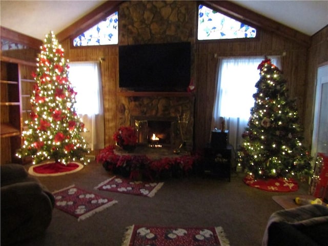 carpeted living room featuring a fireplace, lofted ceiling, and wood walls