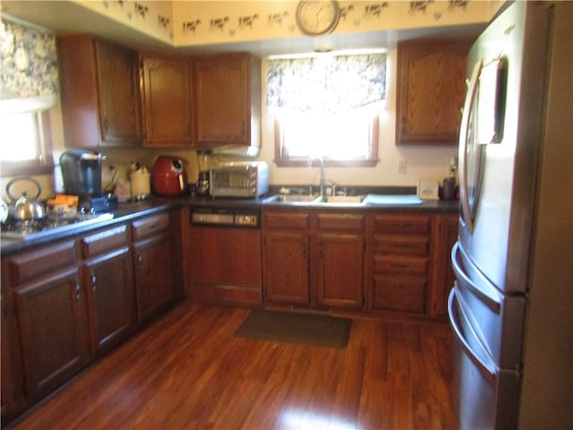 kitchen with dark hardwood / wood-style flooring, cooktop, sink, white refrigerator, and dishwasher