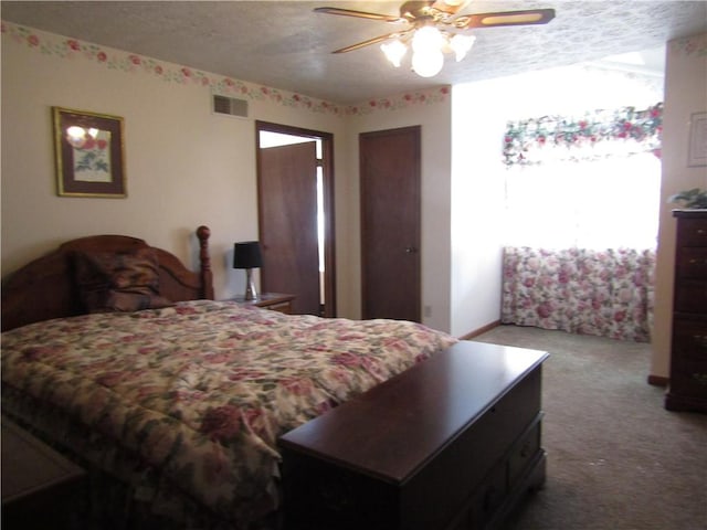 carpeted bedroom with a textured ceiling and ceiling fan