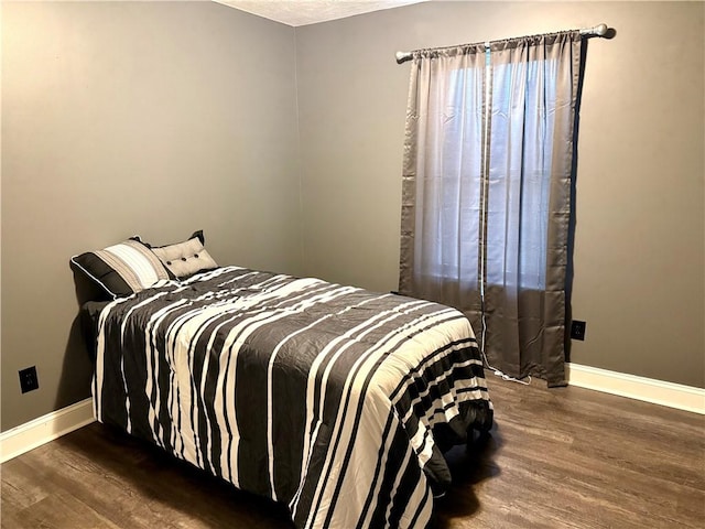 bedroom with dark hardwood / wood-style floors