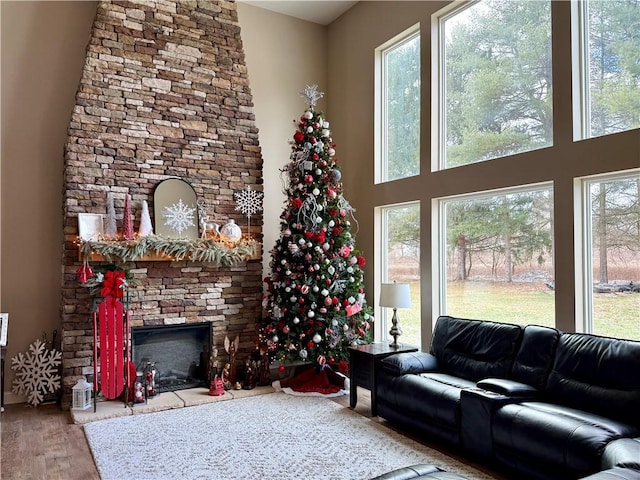 living room featuring a stone fireplace, a wealth of natural light, and hardwood / wood-style floors