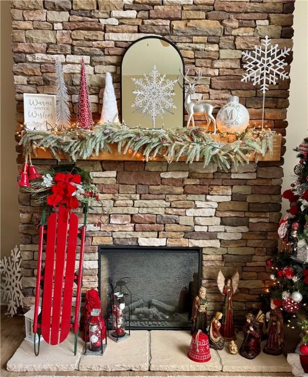 details featuring hardwood / wood-style floors and a stone fireplace