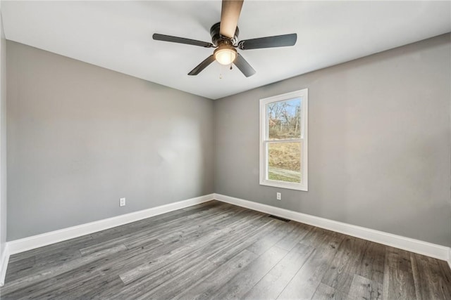 empty room featuring ceiling fan and dark hardwood / wood-style flooring