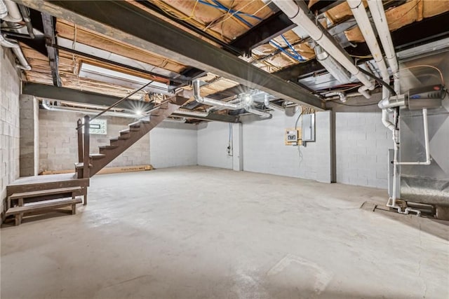 basement featuring electric panel and heating unit