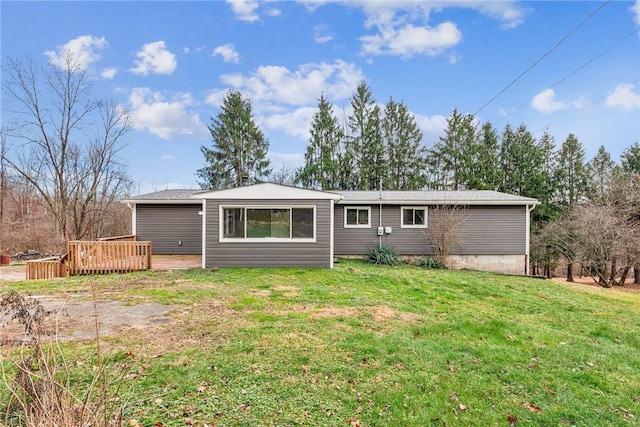 rear view of property with a lawn and a wooden deck