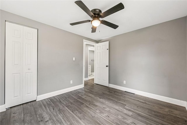 unfurnished bedroom featuring a closet, ceiling fan, and dark hardwood / wood-style flooring