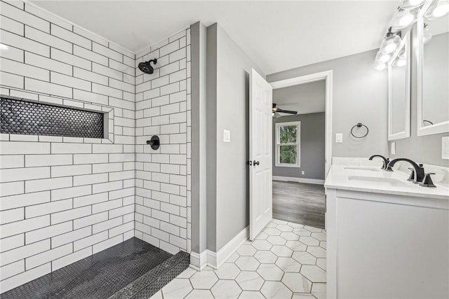 bathroom featuring tile patterned flooring, a tile shower, vanity, and ceiling fan