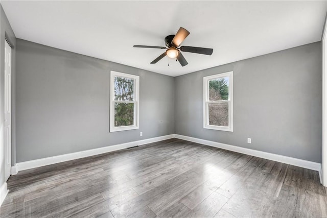 empty room with dark hardwood / wood-style flooring and ceiling fan