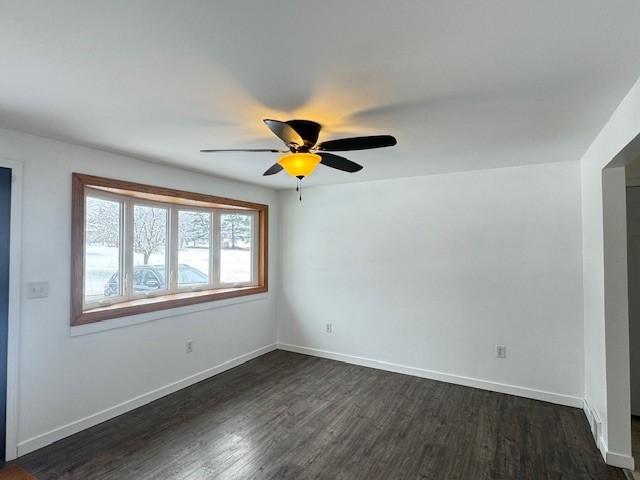 spare room with ceiling fan and dark hardwood / wood-style flooring