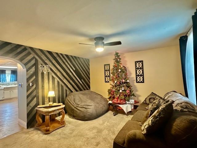 carpeted living room featuring ceiling fan