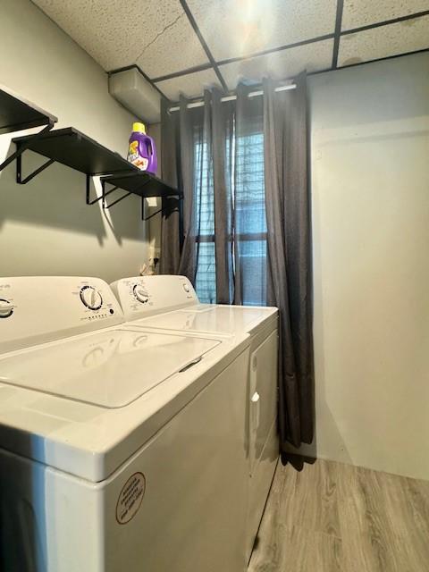 laundry room featuring separate washer and dryer and hardwood / wood-style flooring