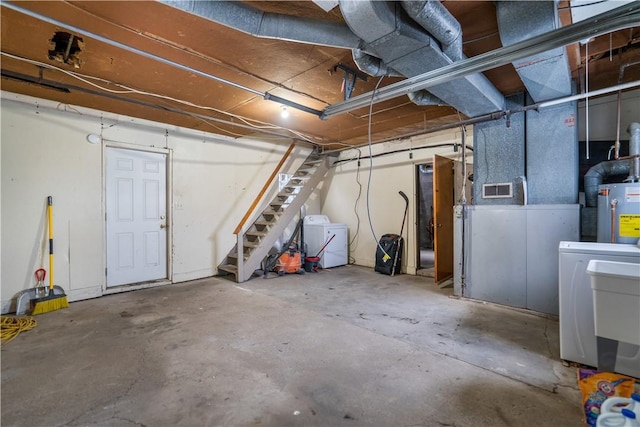 basement featuring washer and clothes dryer and water heater