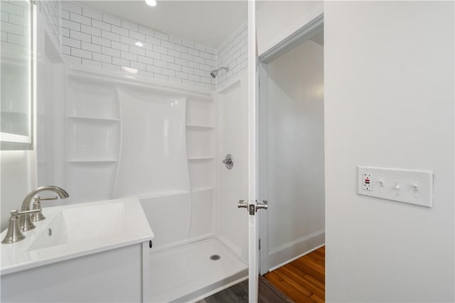 bathroom with a shower, vanity, and hardwood / wood-style flooring