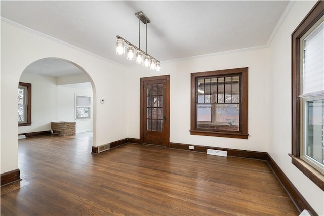 empty room with ornamental molding, dark hardwood / wood-style flooring, and a healthy amount of sunlight