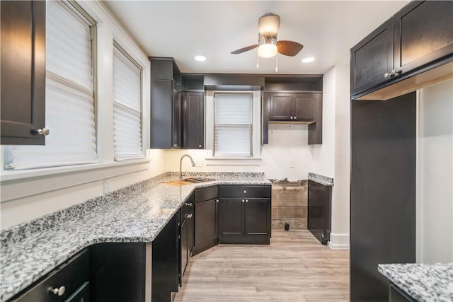 kitchen featuring ceiling fan, light stone countertops, and light hardwood / wood-style flooring