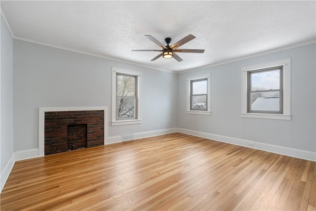 unfurnished living room featuring a textured ceiling, light wood-type flooring, ceiling fan, and crown molding