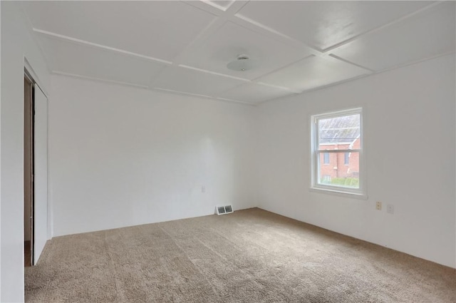 unfurnished room with carpet floors and coffered ceiling