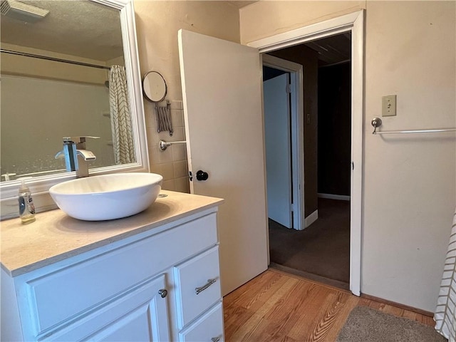 bathroom featuring vanity, curtained shower, and wood-type flooring