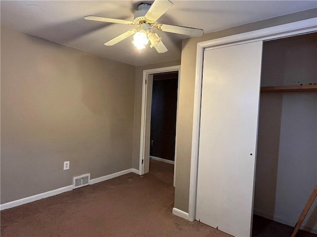 unfurnished bedroom featuring dark colored carpet, ceiling fan, and a closet