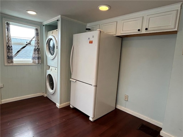 laundry room with dark hardwood / wood-style flooring and stacked washer and dryer