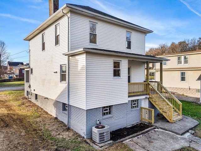 rear view of house featuring covered porch and cooling unit