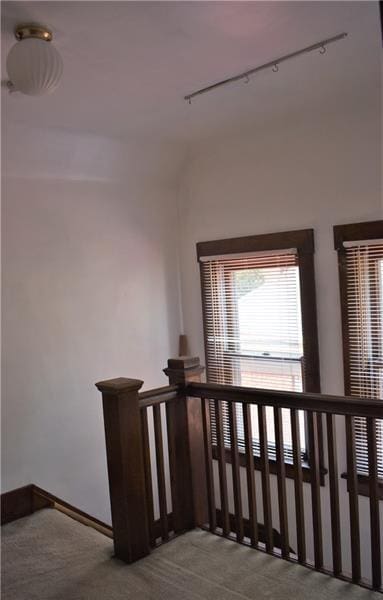 staircase featuring carpet and track lighting