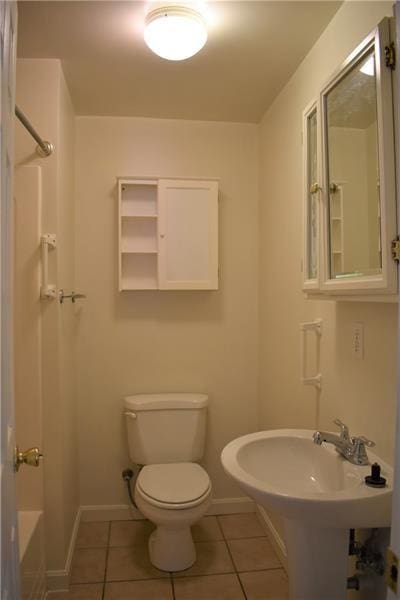 bathroom with toilet, shower / tub combination, and tile patterned floors