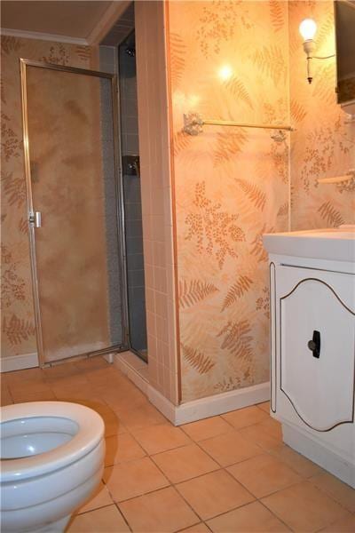 bathroom with tile patterned flooring, toilet, and crown molding