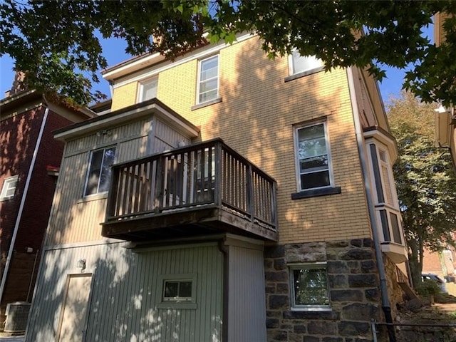 rear view of property featuring a balcony and cooling unit