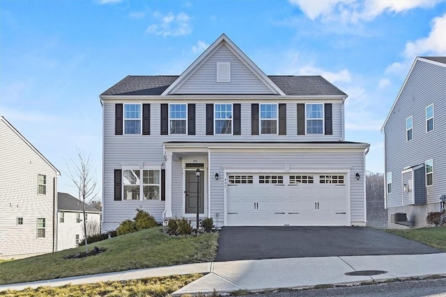 view of property with a garage and a front yard