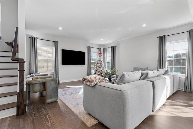 living room with dark wood-type flooring and a healthy amount of sunlight