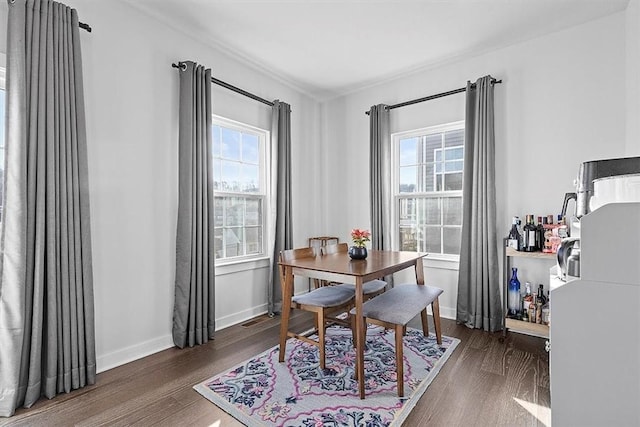 dining area with plenty of natural light and dark wood-type flooring